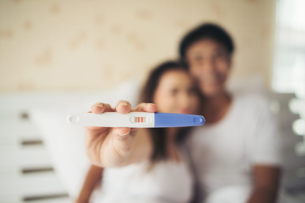 excited new parent hand show pregnancy test